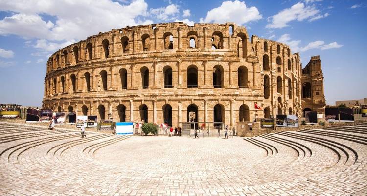 Anfiteatro romano bajo un cielo soleado y brillante.