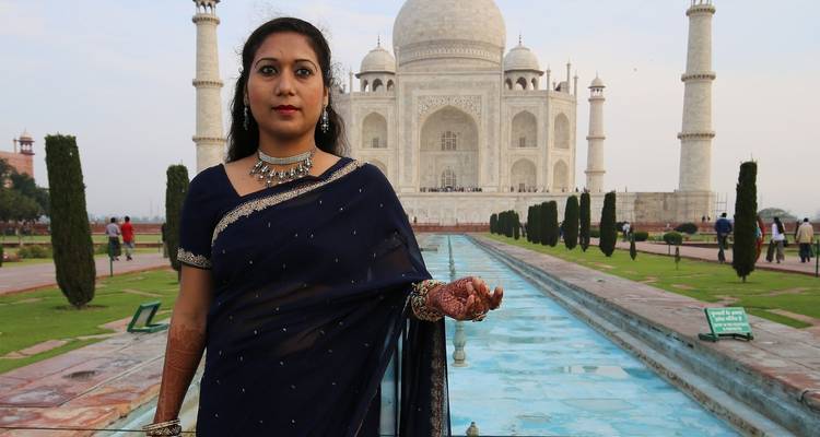 Une femme en tenue traditionnelle devant le Taj Mahal.