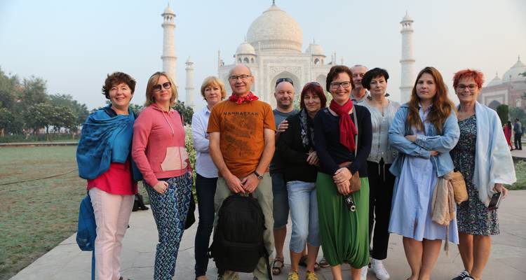 Un groupe de touristes posant devant le Taj Mahal.