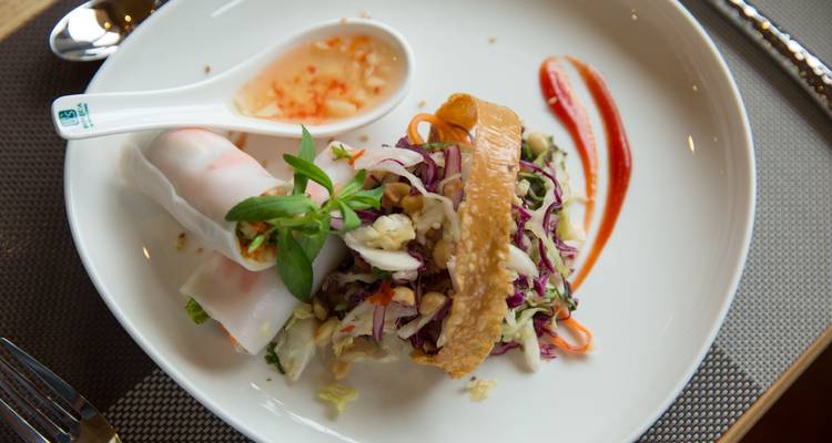 Plat vietnamien gastronomique élégamment dressé dans une assiette blanche.