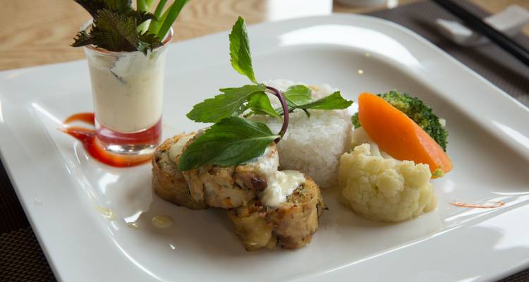 Repas bien présenté avec du riz et des légumes dans une assiette rectangulaire.