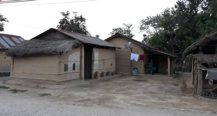 Rural houses with tin roofs and people visible.