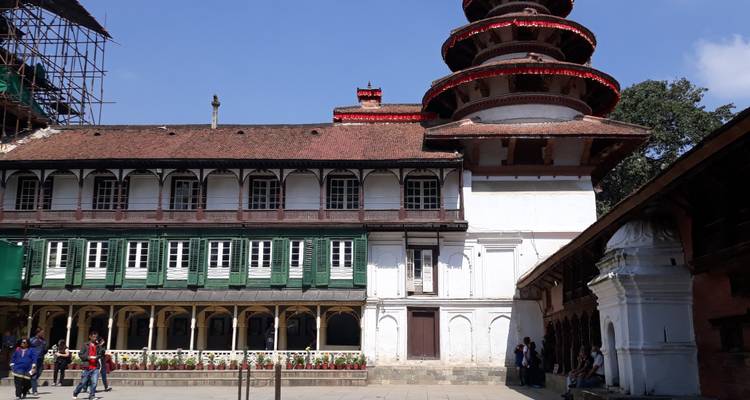 Large traditional building with lush surroundings.