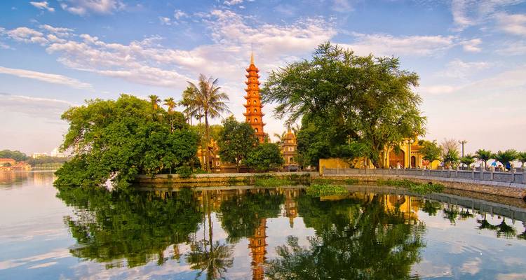 Une pagode ancienne le long de la rivière avec des reflets dans l'eau.
