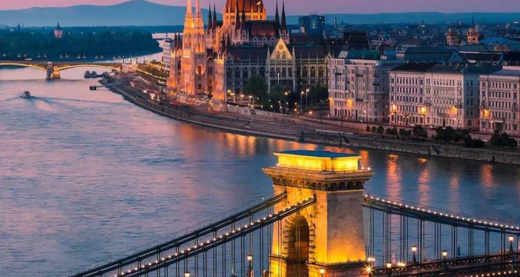 Schemering uitzicht op de Kettingbrug van Boedapest en het verlichte Parlementsgebouw dat weerspiegelt in de Donau.