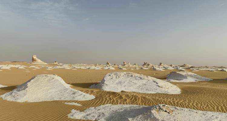 Desierto arenoso con distintivas formaciones rocosas blancas.