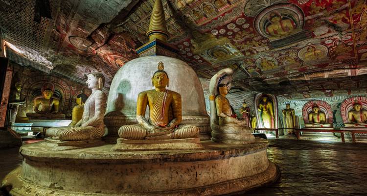 Interior of Dambulla Cave Temple with Buddha statues and painted ceilings.