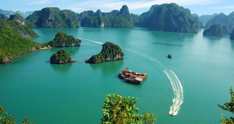 Bahía de Halong con barcos e islas de piedra caliza con un mar turquesa.