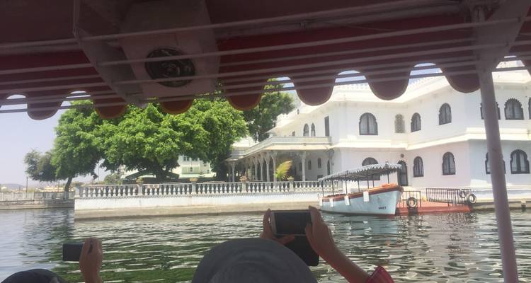 Toeristen op een boot die een paleis aan het meer bekijken.