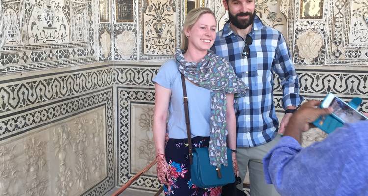 Toeristen die poseren voor gedetailleerde muurschildering.