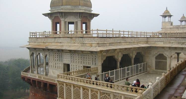 View of an architectural balcony with a few people standing.