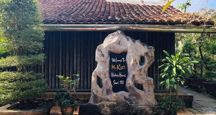 Exterior de una casa histórica de madera con plantas.