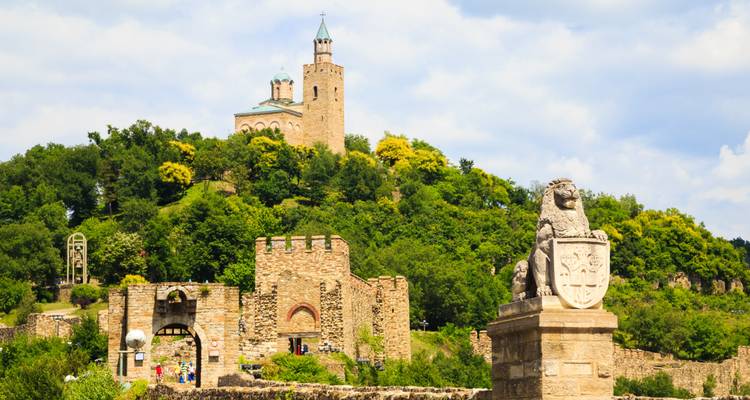 Stenen muren en torens van het Tsarevets Fort die oprijzen boven een groene heuvel in Veliko Tarnovo.