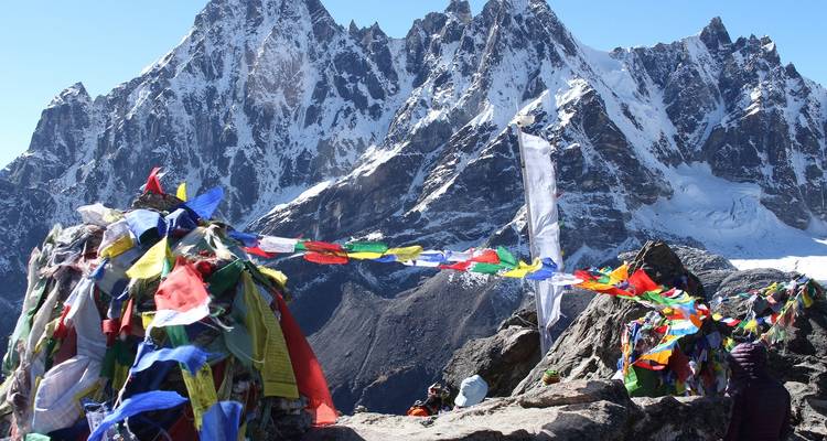 Banderas de oración coloridas con grandes picos montañosos de fondo.