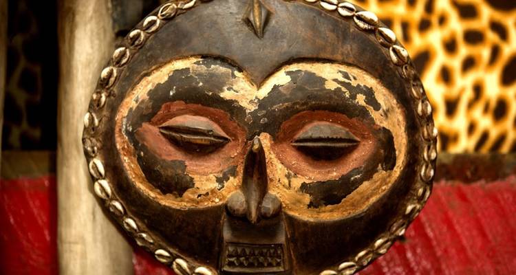 Gros plan d'un masque africain traditionnel avec des détails complexes.