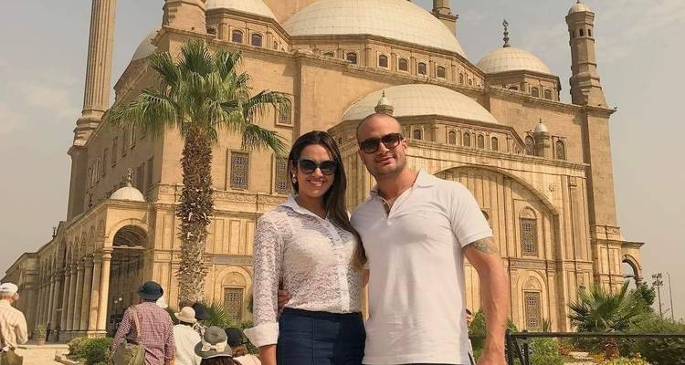 Stel dat glimlacht voor grote moskee met koepels en minaretten.