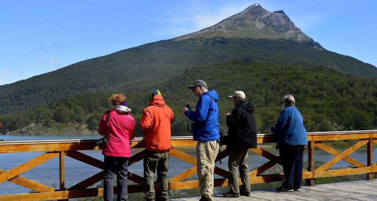 Des touristes observant un paysage montagneux depuis un balcon.