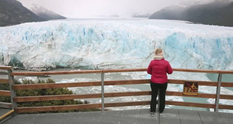 Une personne regardant un grand glacier.
