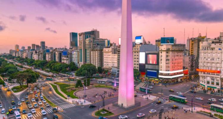 Obelisco de Buenos Aires op een drukke stadsstraat bij zonsondergang.