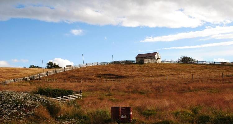 Una pequeña casa en una colina cubierta de hierba en el Parque Nacional Tierra del Fuego.