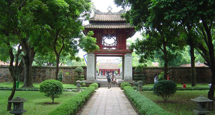 Historischer Tempeleingang durch einen baumgesäumten Weg.