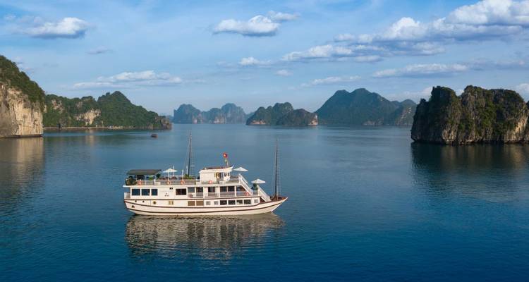 Traditionelles Boot, das durch eine malerische Bucht mit Kalkstein-Karst fährt.