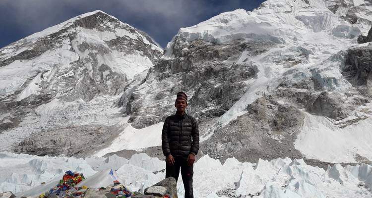 Person, die vor schneebedeckten Bergen steht.