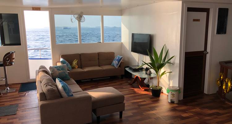 Salon confortable avec canapés et vue sur la mer à l'intérieur d'un navire d'habitation.