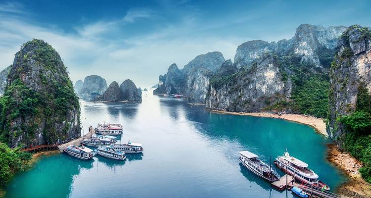 Hermosa vista de la Bahía de Halong con barcos y formaciones kársticas.