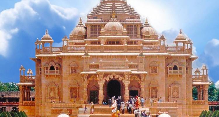 Elaborate Akshardham Temple with decorative domes and ornate carvings under a bright sky.