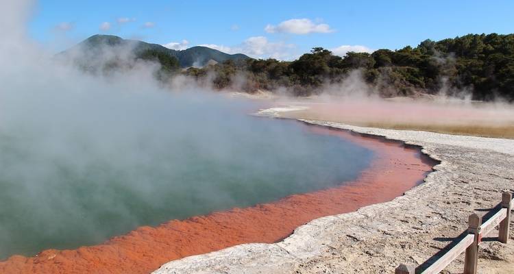 Dampfender geothermaler Pool mit farbigen Ablagerungen an den Rändern.