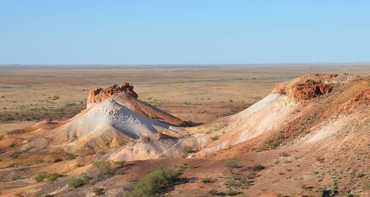 Impresionantes colinas erosionadas rojas y blancas rodeadas de vastas llanuras.