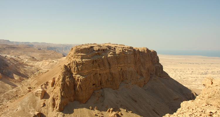 Rugged desert mesa of Masada towering above the Judean Desert and Dead Sea plain.