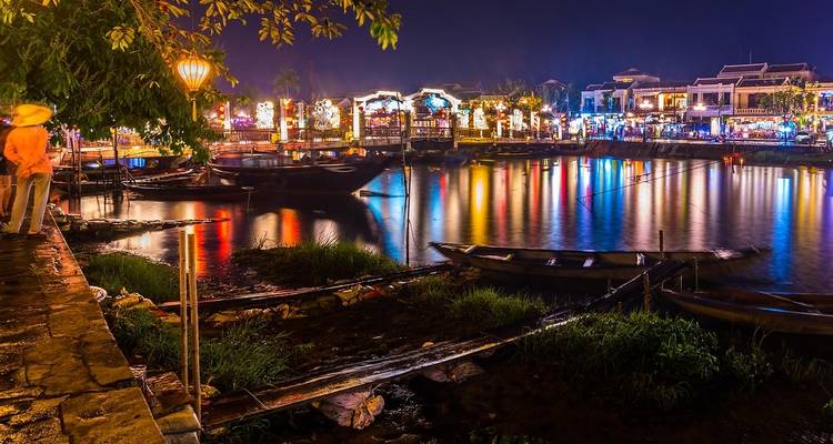 Vista escénica del río con luces vibrantes reflejándose en la noche.