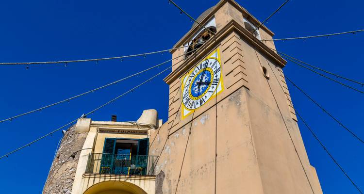 La tour de l'horloge aux carrelages colorés s'élève contre un ciel bleu profond de Capri.