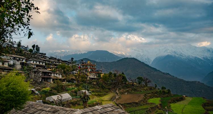 Pintoresco pueblo de montaña con campos en terrazas al atardecer.
