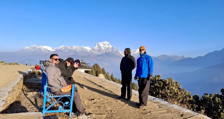 Excursionistas disfrutando de una vista montañosa con picos nevados.