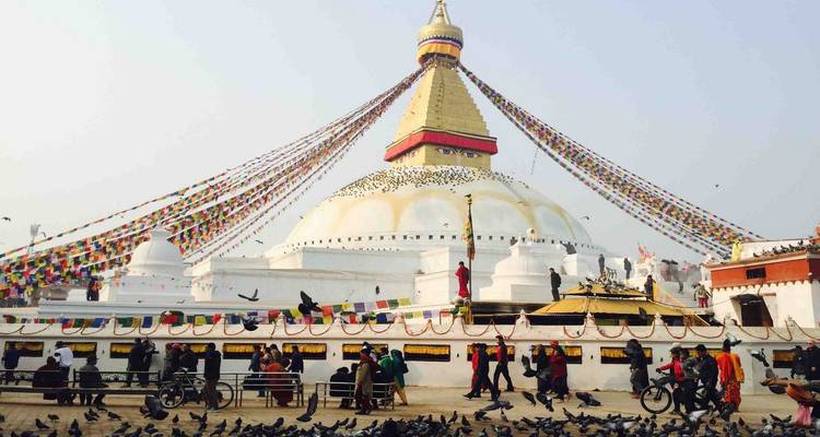 Estupa de Boudhanath with banderas de oración ondeando y visitantes.