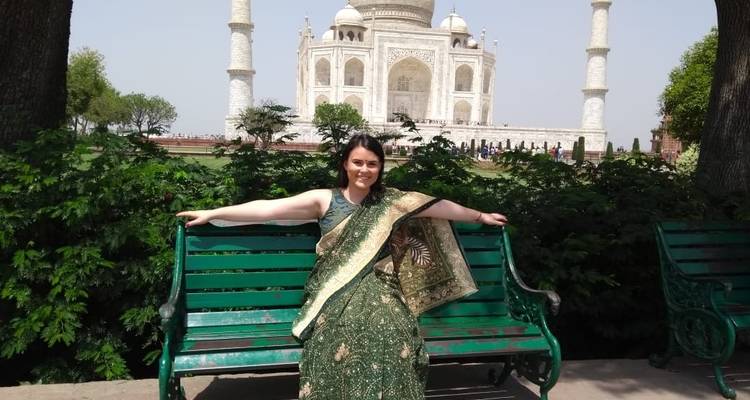 Mujer sentada en un banco frente al Taj Mahal