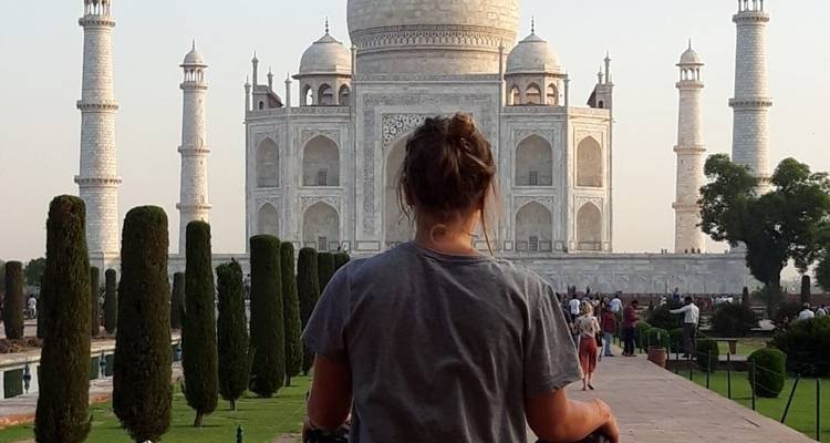 Persona de pie frente al Taj Mahal al atardecer