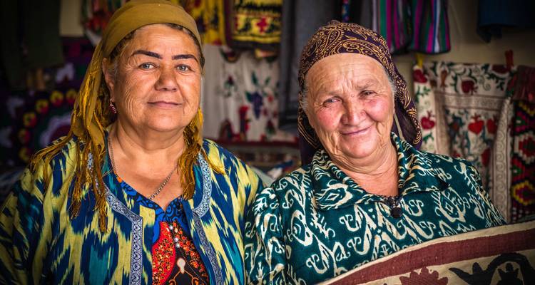 Deux femmes en tenue traditionnelle souriant à la caméra.