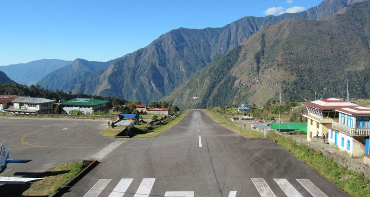 Pista de aterrizaje en una zona montañosa con edificios pequeños.