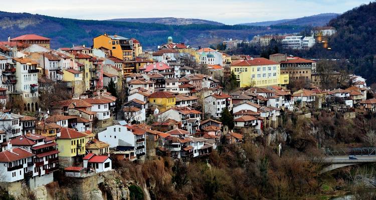 Un pueblo en la ladera con edificios coloridos y un telón de fondo pintoresco.