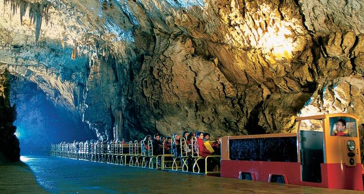 Una cueva subterránea con un tren que transporta turistas.