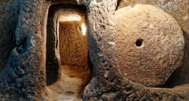 Cueva subterránea con paredes de piedra e iluminación en Capadocia.