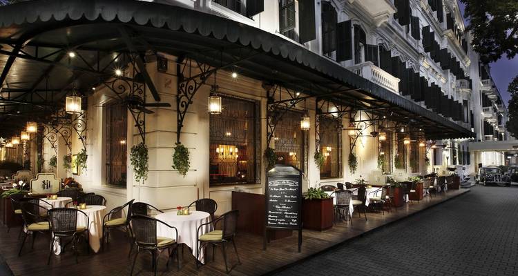 Un restaurante elegante con asientos al aire libre por la noche.