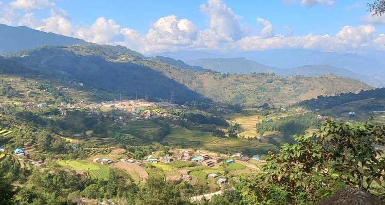 Amplios valles en terrazas y pequeños pueblos dispersos por colinas verdes y exuberantes bajo nubes dispersas.
