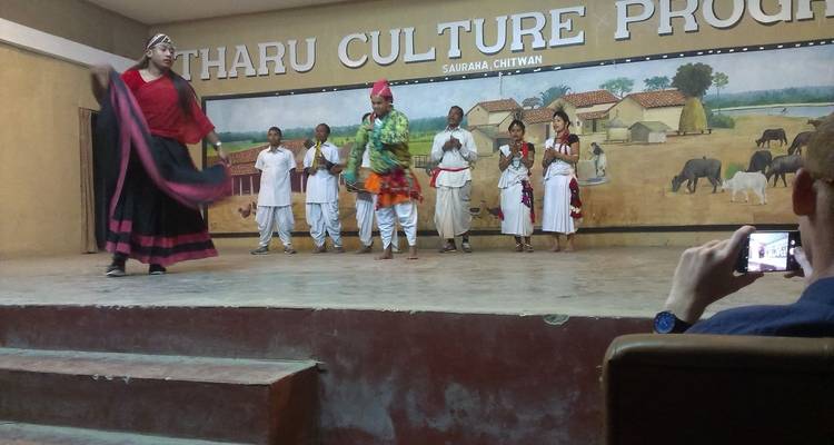 Artiesten in traditionele kostuums op een podium in Chitwan.