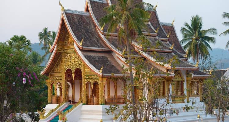 Sierlijke tempel met gouden details en palmbomen.