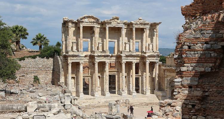 Ruinen einer antiken Bibliothek mit Touristen, die sie erkunden.